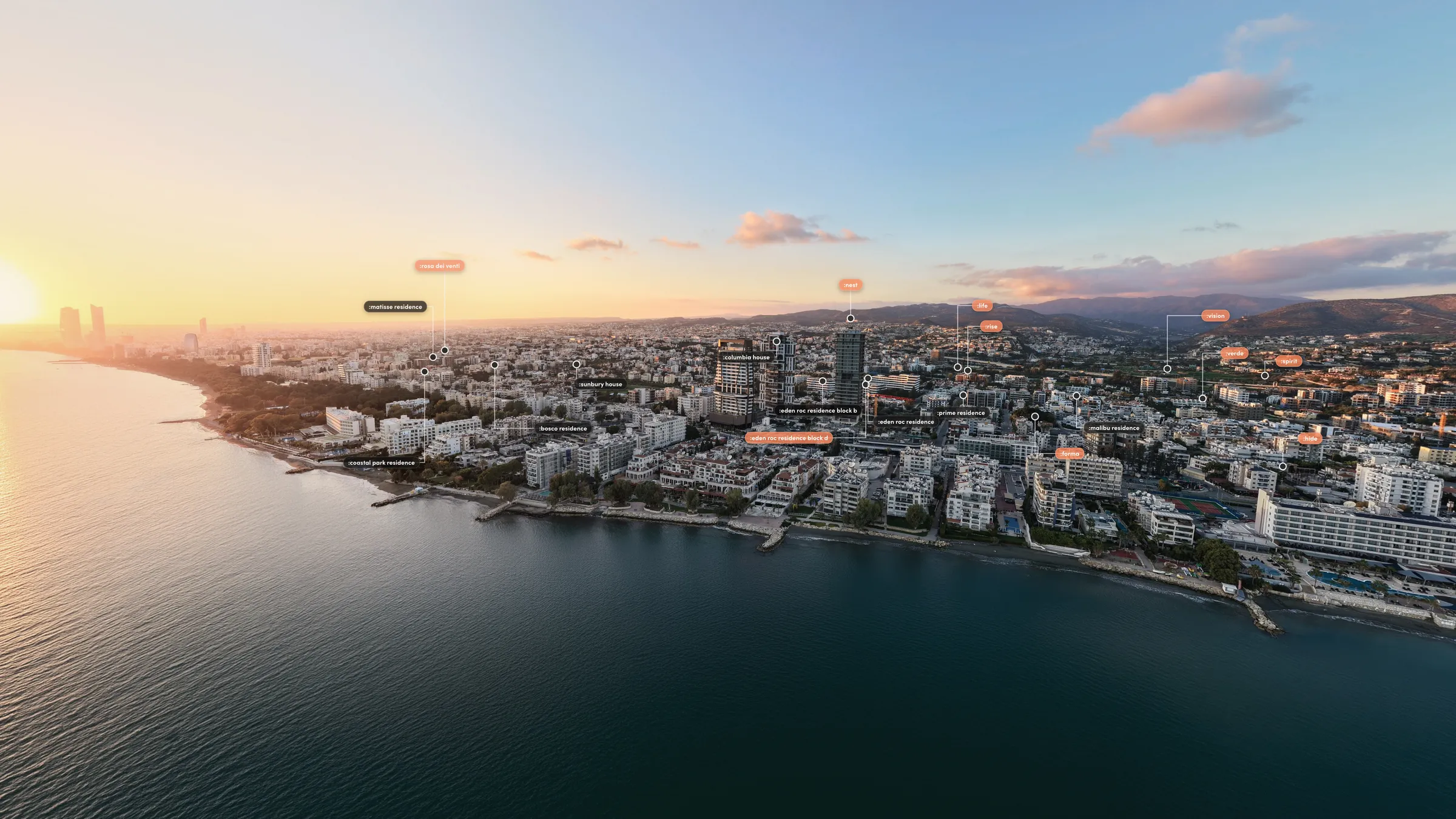 Aerial view of a coastline city at sunset with developer projects marked by name pins